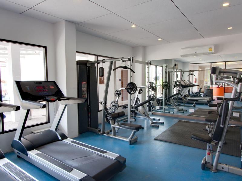 Moderner Fitnessraum mit Laufbändern, Kraftgeräten und Spiegelwänden