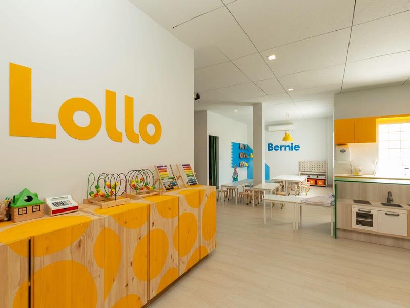 Heller Kinderspielbereich mit bunten Möbeln und Wandschriften in einem Hotel oder Ferienhaus.