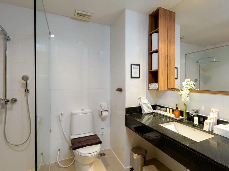 Moderner Hotelbadezimmer mit Dusche, Toilette und Waschbecken mit großem Spiegel.