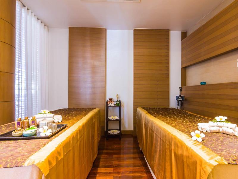 Ruhiger Wellnessraum mit zwei Massageliegen, Holzverkleidung und entspannter Beleuchtung.