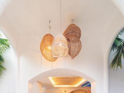 Weißer Bogenraum mit modernen Lampen, zwei Sofas und weiterem Sitzbereich im Hintergrund.