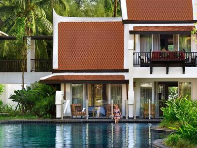 Ein modernes Hotel mit rotdach und Gäste, die am Pool entspannen