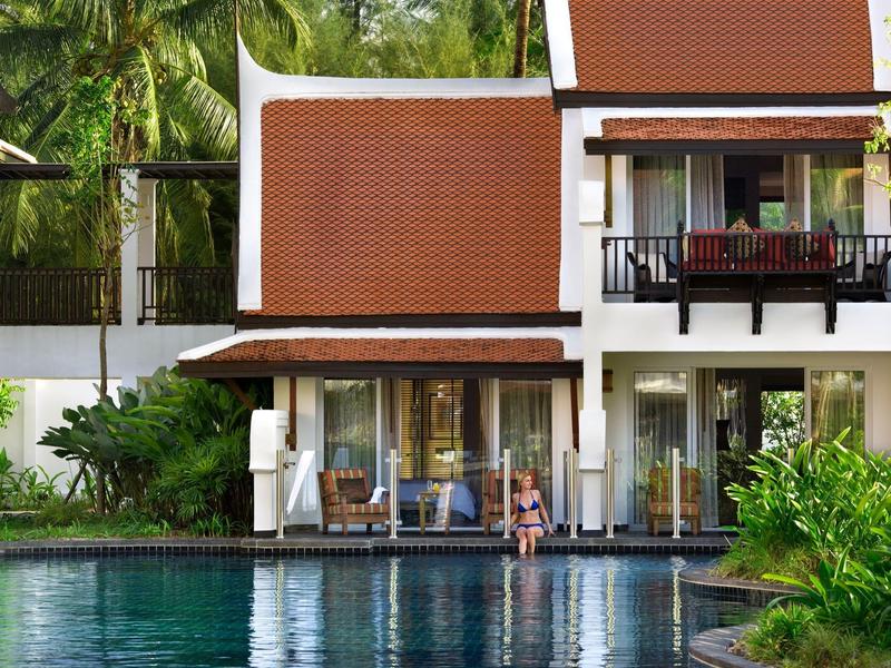 Ein modernes Hotel mit rotdach und Gäste, die am Pool entspannen