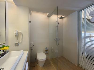 Bagno moderno con doccia in vetro, WC e lavabo con specchio e asciugacapelli.