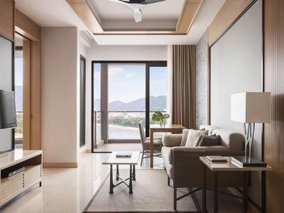 Soggiorno moderno con divano, poltrone e grande finestra con vista sulle montagne.