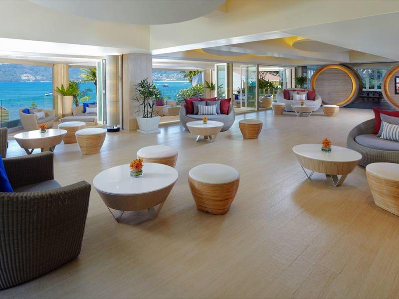 Area lounge moderna dell'hotel con comodi posti a sedere e vista sul mare.