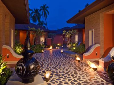 Vue nocturne d'un chemin d'hôtel éclairé avec décoration orientale et palmiers