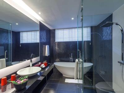 Bagno moderno con vasca freestanding, doccia in vetro e grande specchio.