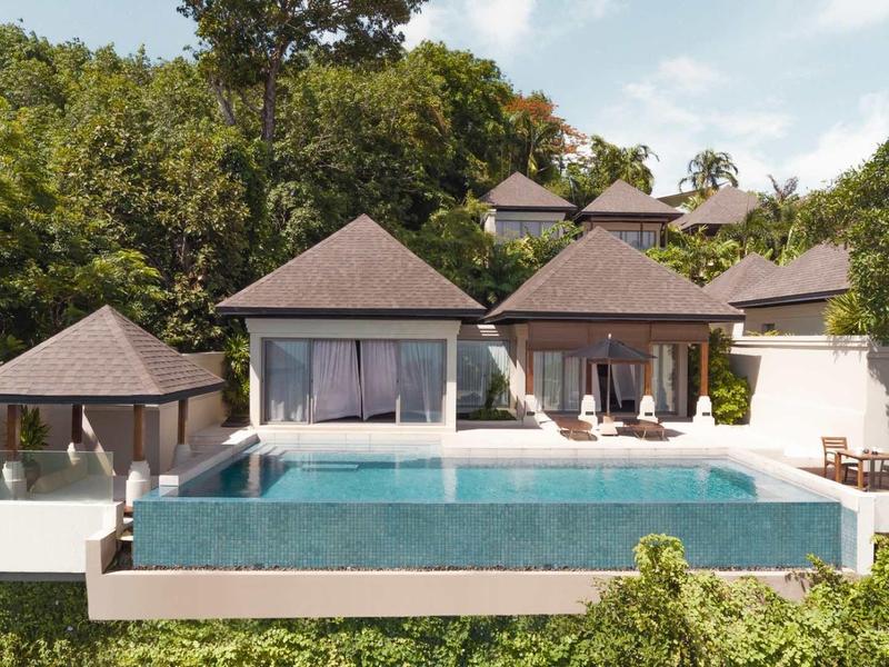 Villa di lusso con piscina a sfioro e facciata bianca circondata da vegetazione rigogliosa.