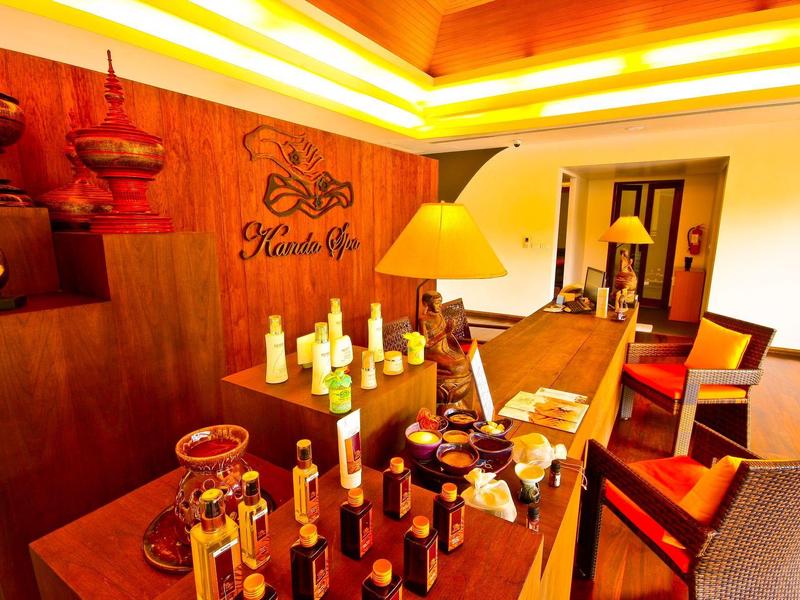 Przytulny bar hotelowy z ciepłym oświetleniem, drewnianym ladą i różnymi butelkami.