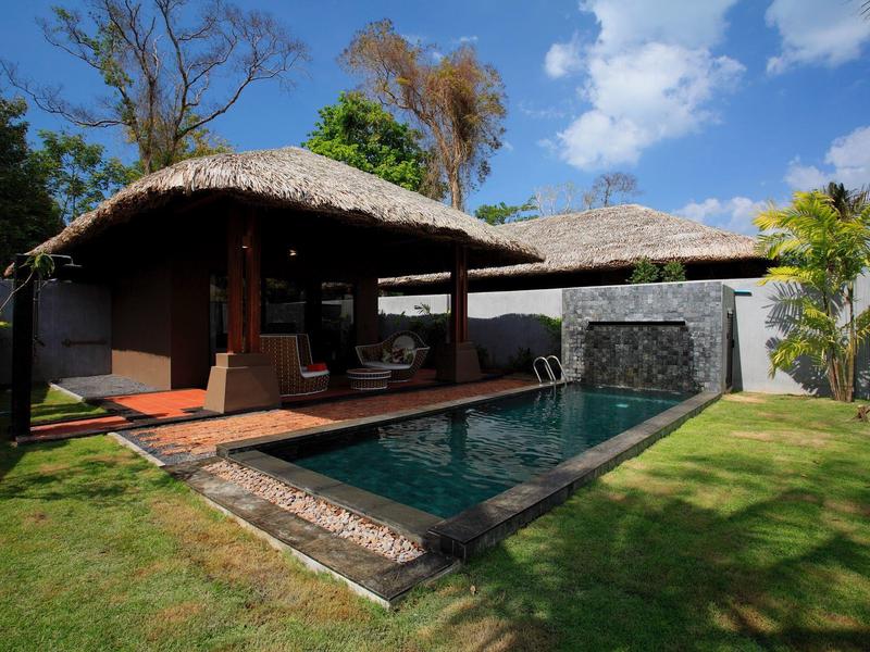 Nowoczesny bungalow z dachem ze strzechy i prywatnym basenem w nasłonecznionym ogrodzie.