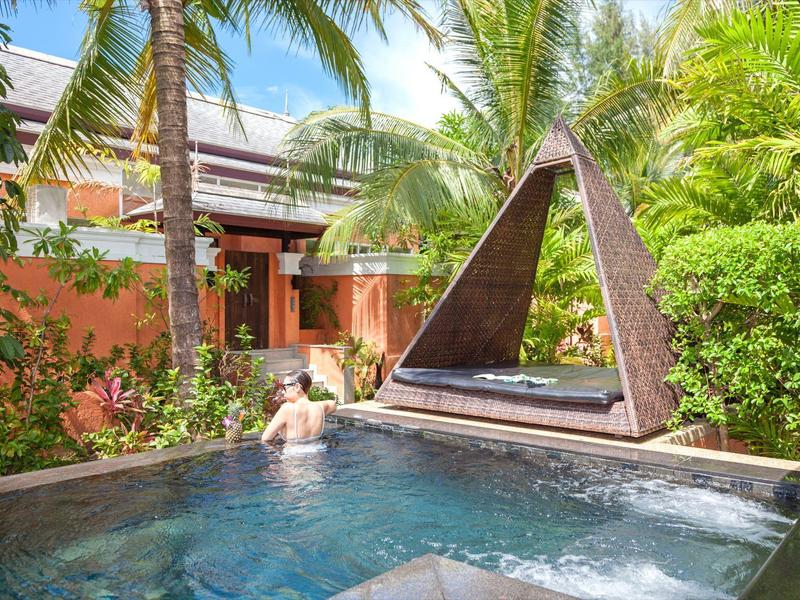 Luksusowy basen z leżanką i tropikalną roślinnością w hotelu.