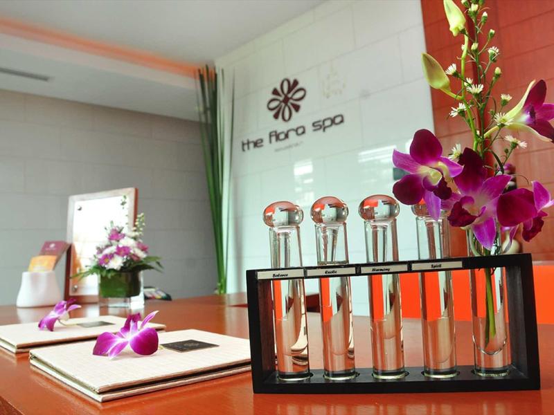 Ein stilvoller Spa-Bereich mit Orchideen, Glasflaschen in Halterung und gedämpfter Beleuchtung.