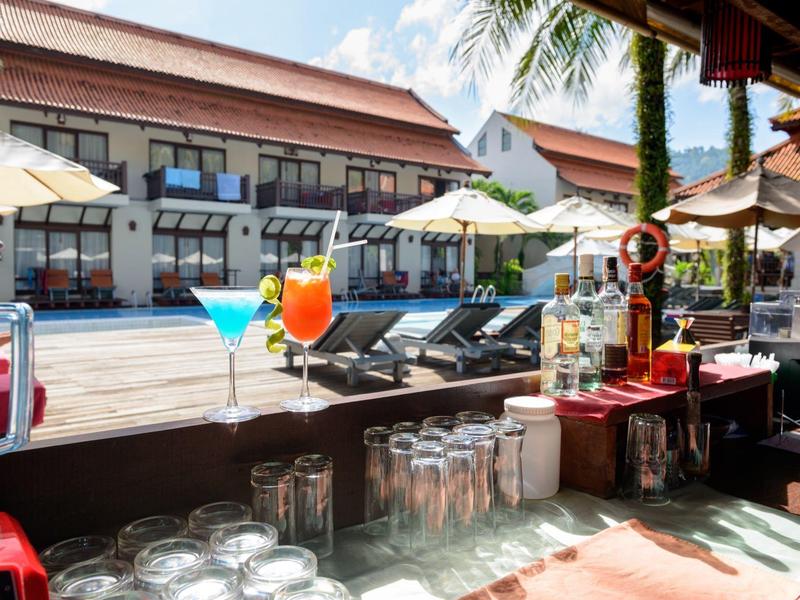 Levendige poolbar met cocktails, ligstoelen en parasols voor een tropisch hotel.