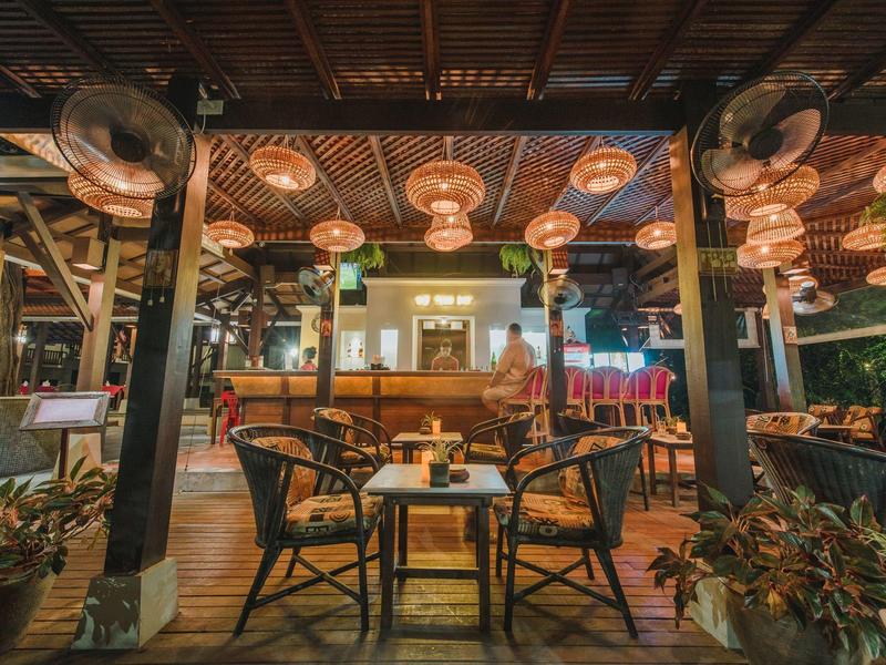 Gezellige lounge met houten plafond, verlichting en zithoek in een hotel.