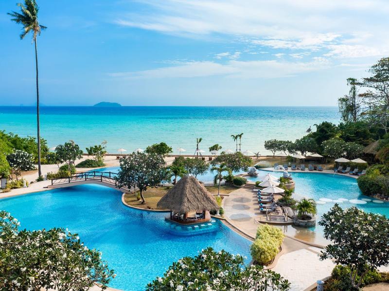 Round pool with sun umbrellas and view of the sea and blue sky
