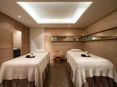 Stanza benessere tranquilla con due comodi lettini da massaggio e illuminazione soffusa.