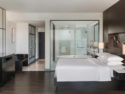 Camera d'albergo moderna con letto grande, doccia in vetro e arredamento minimalista.