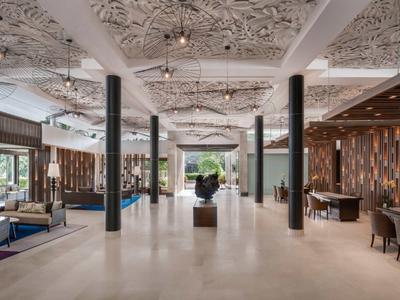 Ampia hall dell'hotel con soffitto artistico, aree salotto e decorazioni moderne.