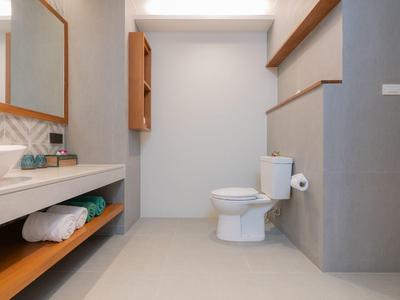 Modern bathroom with sink, toilet, and bright, minimalist design.