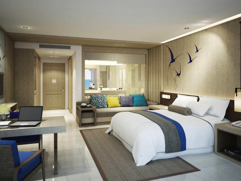 Moderne hotelkamer met comfortabel bed, bureau en zithoek.