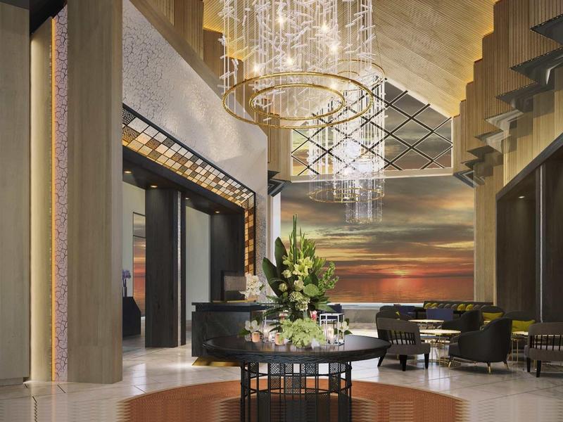 Elegante hotel lobby met kroonluchters, zithoek en kleurrijke wanddecoratie.