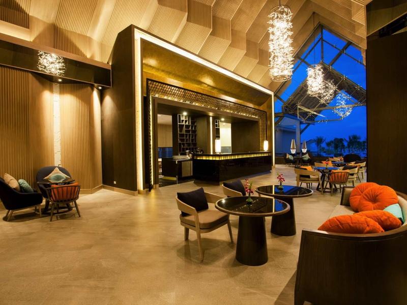 Elegante hotel lounge met moderne meubels en groot panoramisch raam met uitzicht op de zonsondergang.