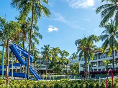 Hotel met zwembad, glijbaan en palmbomen onder blauwe lucht