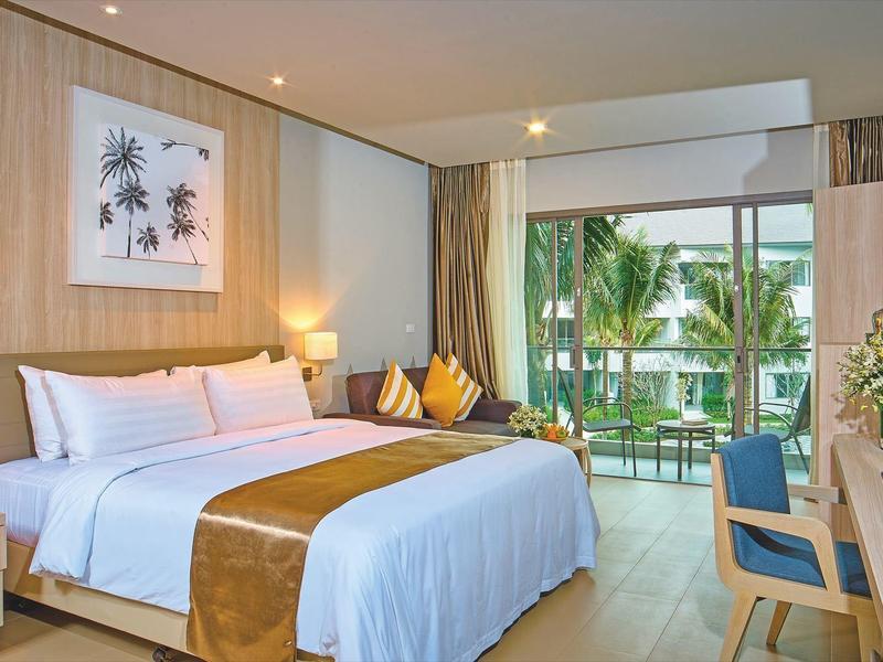 Modern hotelkamer met groot bed, houten meubels en balkon met uitzicht op palmbomen.