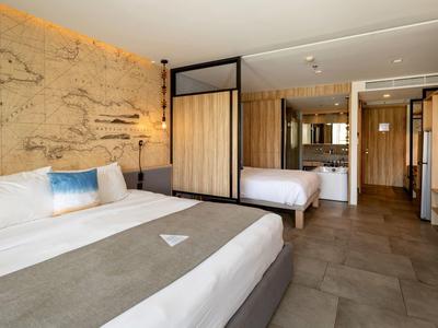 Modern hotel room with two beds and elegant wood paneling.