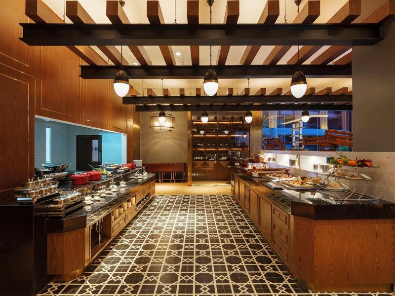 Elegante sala de desayuno con luz cálida, vigas de madera y encimeras de mármol.