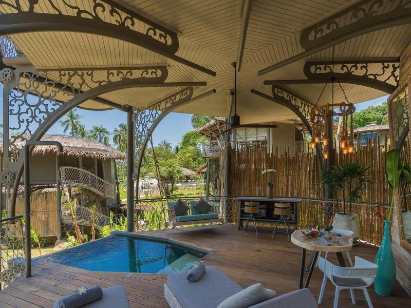 Una coppia si rilassa in un'area spa aperta con piscina e ambiente tropicale.