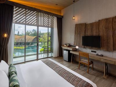 Chambre d'hôtel lumineuse avec grand lit, bureau et balcon donnant sur la piscine.