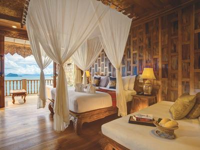 Camera d'hotel di lusso con letto a baldacchino, pareti in legno e vista sul mare