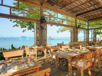 Ristorante aperto con mobili in legno e vista mare in una giornata di sole