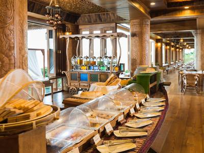 Area colazione elegante con buffet, colonne in legno e illuminazione moderna.