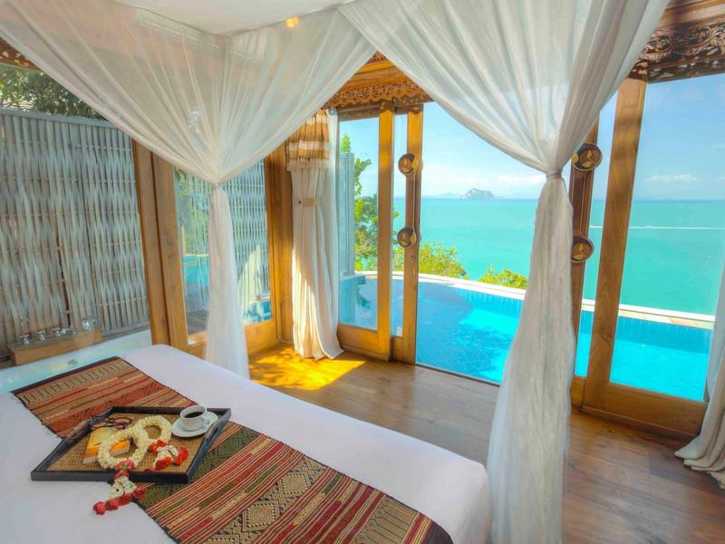 Camera d'hotel lussuosa con porta aperta su piscina privata e vista mare.