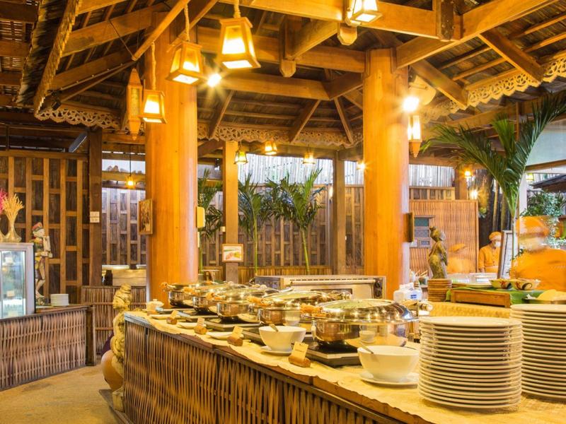 Area buffet in un ristorante di legno con lampade accese e tavolo apparecchiato.