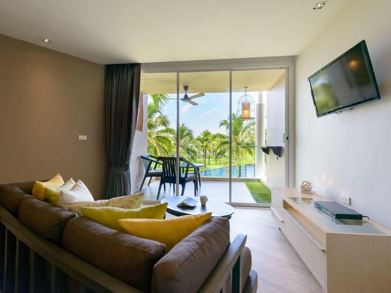 Salon moderne avec canapé marron, coussins jaunes et vue sur terrasse avec piscine.