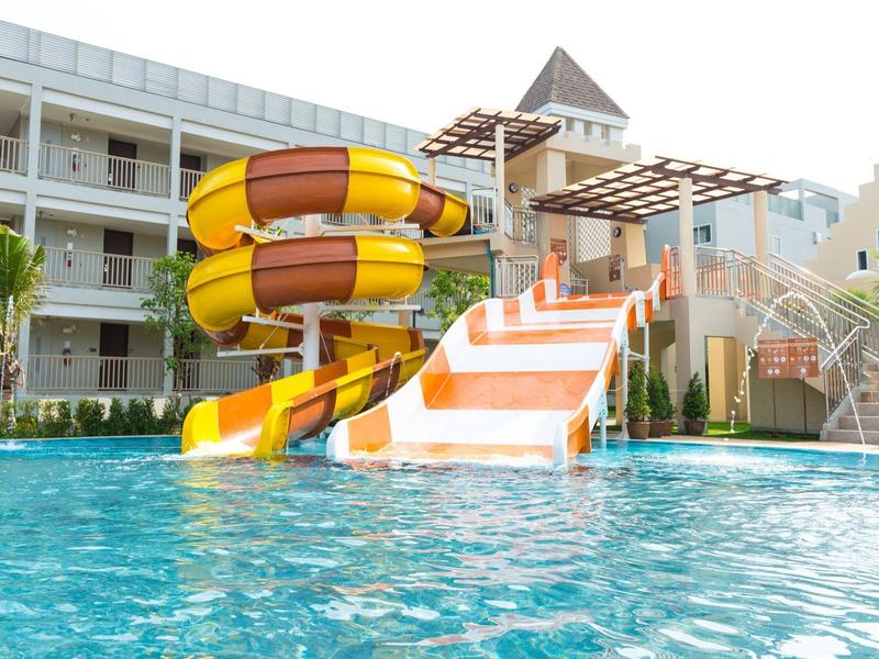 Parc aquatique de l'hôtel avec toboggans colorés et eau de piscine claire.