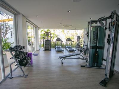 Heller, moderner Fitnessraum mit Gym-Geräten und großen Fenstern zur Gartenseite.