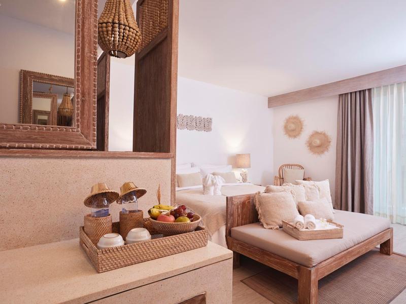 Przytulny pokój hotelowy z łóżkiem, dekoracjami koszowymi i dużym lustrem.