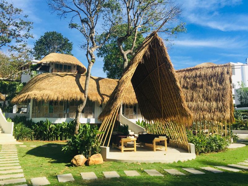 Przytulny kącik wypoczynkowy z dachówką z trzciny w ogrodzie ośrodka pod niebieskim niebem.