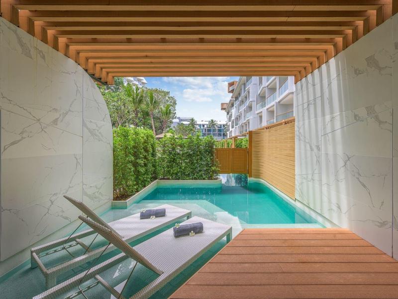 Vista da una terrazza con lettini su una piscina privata e area giardino
