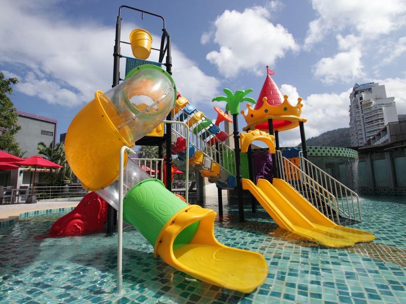 Attrezzatura da gioco colorata per bambini con scivoli in una piscina sotto un cielo nuvoloso.