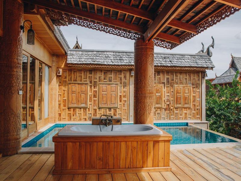 Houten terras met jacuzzi en zwembad voor traditioneel houten huis onder houten dak