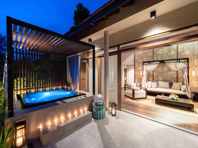 Nowoczesny balkon hotelowy z podświetlanym jacuzzi i stylowym salonem nocą.