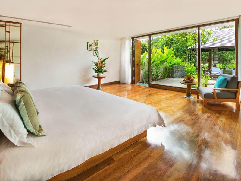 Jasna sypialnia z drewnianą podłogą i widokiem na zielony taras.