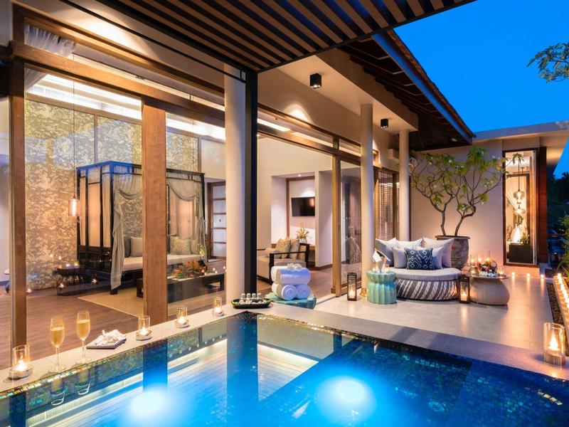 Nowoczesny hotelowy taras z basenem, meblami wypoczynkowymi i nastrojowym oświetleniem wieczornym.