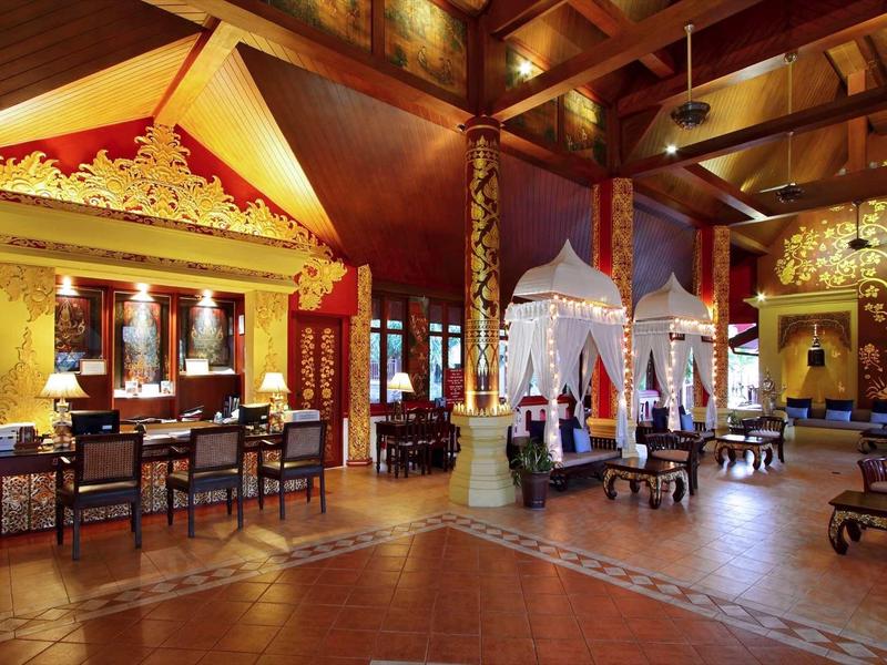 Großer, festlich geschmückter Saal mit Holzdecke, goldenen Verzierungen und vielen Sitzgelegenheiten.